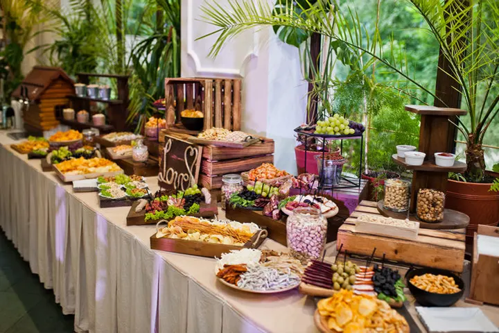A beautifully arranged gourmet snack buffet with a variety of treats and fruits at a birthday party, organized by Joyous Events